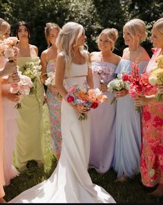 a group of women standing next to each other holding bouquets