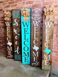 three wooden signs with the words welcome, welcome and welcome on them in front of a brick wall