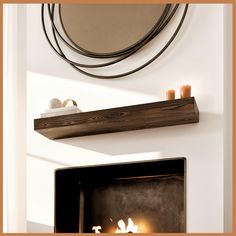 a fire place with candles and a mirror above it