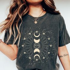 If you've ever looked up at the night sky and felt your spirit soar, our Celestial Boho Moon Shirts are for you. Featuring moon phase astrology and astronomy design, this shirt is a nod to the magic and mystery of the universe. With its comfortable and boho vintage-inspired style, it's an effortlessly cool addition to any outfit. Get ready to channel your inner moon goddess with this mystical shirt. 💫T-SHIRT DETAILS Comfort Colors introduces its garment-dyed t-shirt; a fully customizable tee made 100% with ring-spun cotton. The soft-washed, garment-dyed fabric brings extra coziness to your wardrobe while the relaxed fit makes it an excellent daily choice. The double-needle stitching throughout the tee makes it highly durable while the lack of side-seams helps the shirt retain its tubular Galaxy Shirt, Moon Shirt, Trendy Shirts, Look Plus, Moana, Contemporary Fashion, Modern Fashion, Stylish Shirts, Printed Shorts