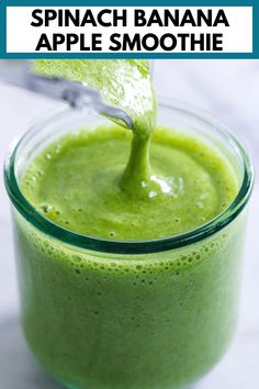 a green smoothie in a glass with a spoon and the words spinach banana apple smoothie