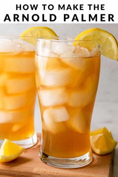 two glasses filled with lemonade and ice on top of a cutting board next to sliced lemons