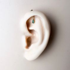 an ear with a green stone in the middle