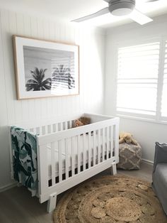 a baby's room with a white crib and rug