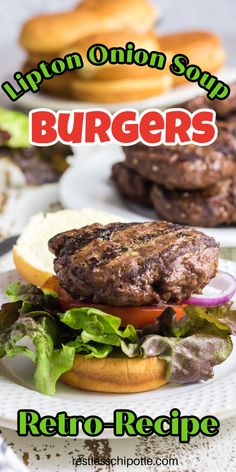 a burger with lettuce, tomato and onion on it sitting on a plate