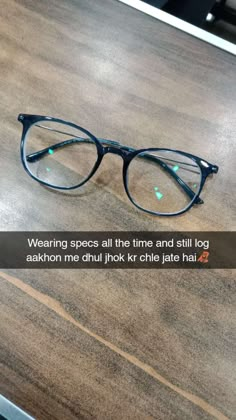 a pair of glasses sitting on top of a wooden table