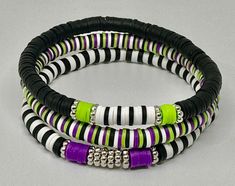 three bracelets with black, white and green beads on each one stranded together