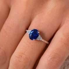 a woman's hand with a ring on it and a blue stone in the middle