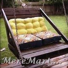 a wooden swing bed with yellow cushions on it