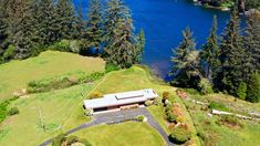 an aerial view of a house on the side of a lake with trees around it