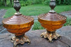 two brown glass vases sitting on top of a rock