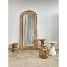 there is a mirror, stools and table in the living room with white walls