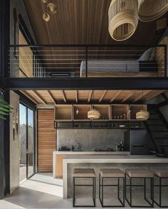 an open kitchen and living room with stairs leading up to the second floor that leads to another level