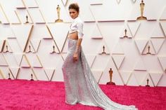 a woman in a silver dress on the red carpet at an oscars event,