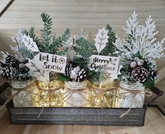 some pine cones are sitting in small glass vases with christmas decorations on them and snow flakes