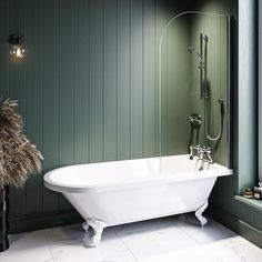 a white bath tub sitting in a bathroom next to a window with green paint on the walls