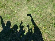 two people standing in the grass with their hands up