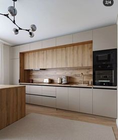 a modern kitchen with wooden cabinets and white walls, an overhead light fixture hangs from the ceiling