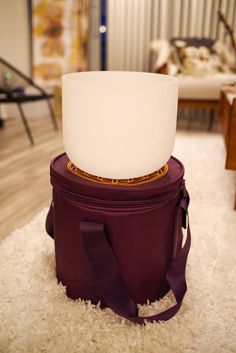 a purple bag sitting on top of a white rug