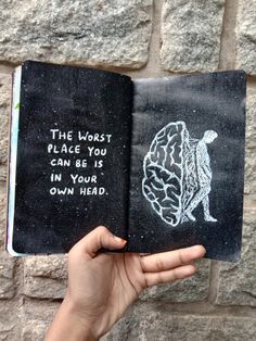 someone is holding up an open book with chalk drawings on it that says, the worst place you can be in your own head