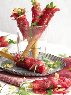 some food is sitting on a plate and in a glass vase with another one behind it