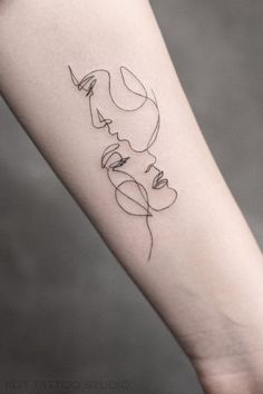 a woman's arm with a line drawing tattoo on the left side of it