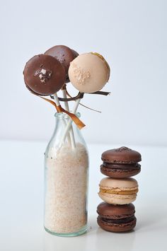 a vase filled with cookies next to a pile of doughnuts