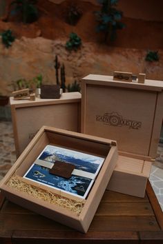 two wooden boxes sitting on top of a table next to each other with pictures in them