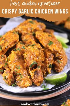 the best chicken appetizer crispy garlic chicken wings on a plate with lime wedges