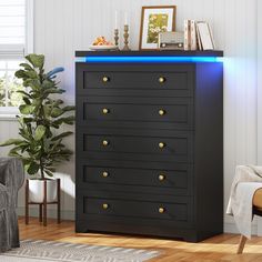 a black chest of drawers with blue lights on the top and bottom, in a living room