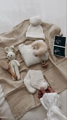 a person is laying on a bed with some stuffed animals and other items around them