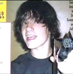 a young man holding up an award in front of him