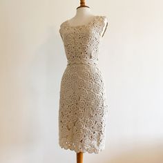 A true rare beauty - vintage 1950s/1960s hand crocheted wool wiggle dress from Capriel labeled an "original import", 100% all wool, hand made in Italy. The crochet has a floral motif and the yarn is a natural color wool with a thinner shinier thread worked in that gives it a very subtle almost metallic effect which is hard to capture in the photos. Has its own crocheted belt to enhance that wiggle silhouette. Fully lined. Very nice condition with a few areas of discoloration to the crochet as sh Fitted Cream Crochet Lace Dress, Beige Fitted Crochet Dress Knee-length, Beige Fitted Knee-length Crochet Dress, Vintage Fitted Crochet Dress For Spring, Elegant Handmade Fitted Dresses, Handmade Fitted Vintage Dress, Fitted Vintage Lace Crochet Dress, Fitted Cream Crochet Dress, Vintage Fitted Dress With Crochet Lace