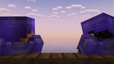 two purple cubes sitting next to each other in front of a body of water