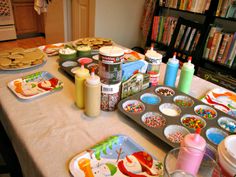 the table is covered with baking supplies and cookies