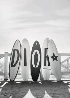 four surfboards are lined up in front of each other with the word dior written on them