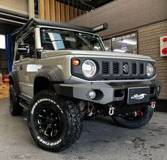 a grey jeep parked in front of a building