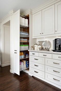 a kitchen with white cabinets and lots of cupboard space in the corner, including a coffee maker