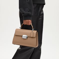 Our Eliza Top Handle has a beloved and timeless silhouette. Crafted of smooth and refined calf leather this bag features multiple inside pockets with plenty of room for essentials like your wallet phone and small accessories. It has a snap closure and an outside open pocket keeping your essentials both secure and easy to access. The detachable strap offers versatile styling options—wear it as a top handle bag or crossbody ideal for both casual and work settings. Modern Top Handle Briefcase With Silver-tone Hardware, Modern Box Bag With Silver-tone Hardware For Daily Use, Daily Use Top Handle Box Bag With Silver-tone Hardware, Leather Box Bag With Silver-tone Hardware For Everyday Use, Rectangular Satchel With Palladium Hardware, Leather Tote Box Bag With Silver-tone Hardware, Leather Satchel Box Bag With Silver-tone Hardware, Modern Leather Box Bag With Top Handle, Modern Leather Top Handle Box Bag