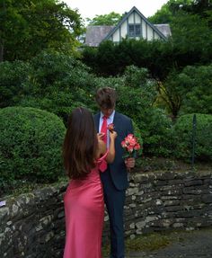 a woman in a pink dress and a man in a blue suit standing next to each other