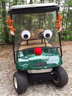 a green golf cart with two eyes on it's head and one red nose