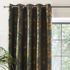 the curtains are hanging on the window sill in front of a potted plant