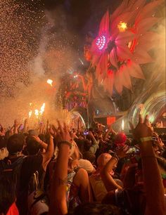 a large group of people at a concert with fireworks and confetti in the air