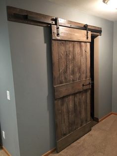 an empty room with a wooden door in the center and carpeting on the floor