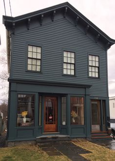 a blue house with three windows on the front