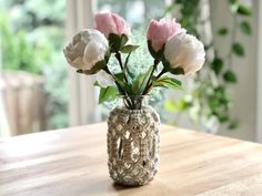 some pink and white flowers in a vase on a table