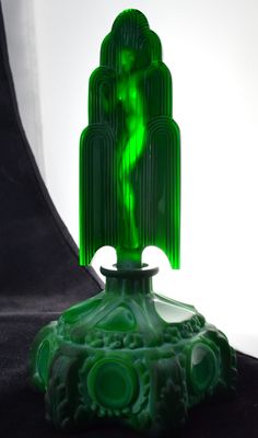 a green glass sculpture sitting on top of a table