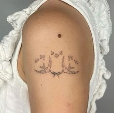 a woman with a tattoo on her shoulder that has three birds flying in the air