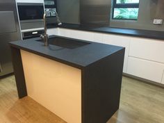 a modern kitchen with an island counter and stainless steel appliances in the backround