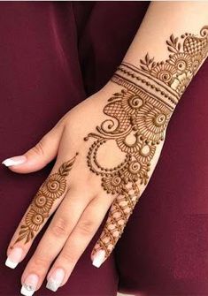 a woman's hand with henna tattoos on her arm and hands, showing the intricate